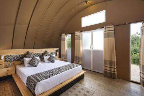 a bedroom with a large bed and large windows at Leopard Nest - Glamping in Yala in Yala