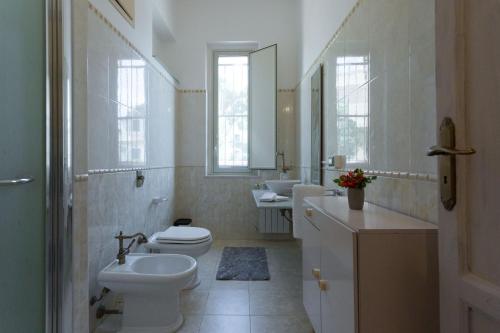 a bathroom with a toilet and sink and two sinks at Mondello House Eraclea in Mondello