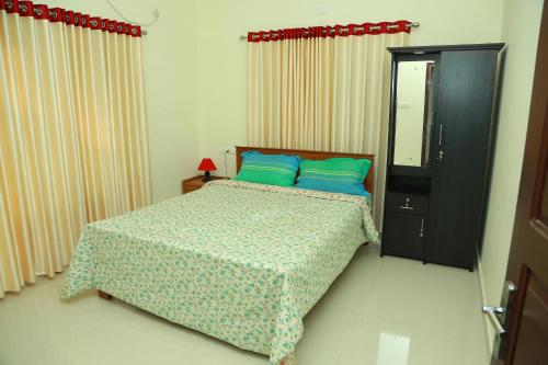 a bedroom with a bed with blue pillows at Friendsland Home Stay in Ernakulam