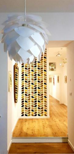 a large white chandelier in a room with a hallway at Napoli Tree - Lungomare in Naples