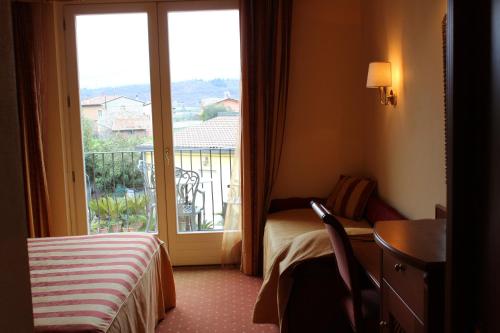 a hotel room with a bed and a window at Hotel La Dolce Vita in Cavaion Veronese