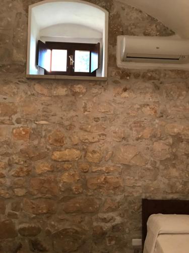 a room with a stone wall with a mirror at Nacalino Agriturismo in Modica