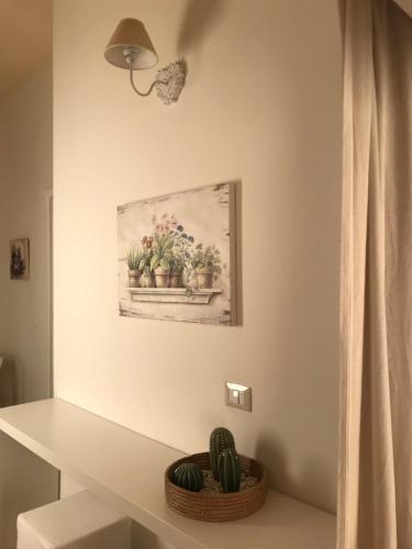 a painting of cactuses in a window in a bathroom at Nacalino Agriturismo in Modica