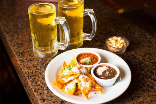a plate of food on a table with two glasses of beer at Conquistador Hotel & Conference Center in Guatemala
