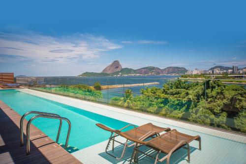 a swimming pool with a view of the water and mountains at Prodigy Santos Dumont by Wish in Rio de Janeiro