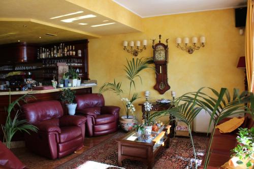 a living room with leather furniture and a clock at Hotel La Dolce Vita in Cavaion Veronese