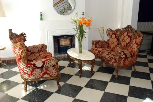 a living room with two chairs and a table with a vase of flowers at Bohemia Hotel Boutique in Mendoza