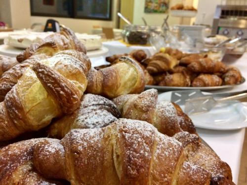 a bunch of pastries on a table with other foods at Hotel Adria in Lignano Sabbiadoro