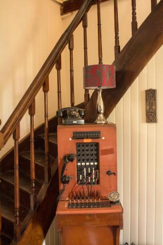 un escalier avec une machine à l'ancienne sur une table dans l'établissement La Petite Auberge, à Carennac
