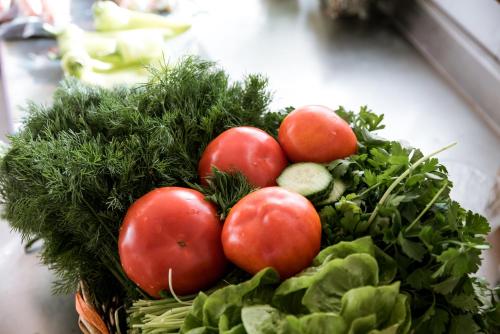 a basket of tomatoes and greens on a table at Madalenas B&B in Pelekas
