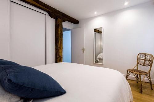 a bedroom with a white bed and a chair at Apartamento Carlos V in Hondarribia