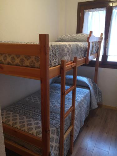 two bunk beds in a room with a window at Apartamento Santa Marina in Tramacastilla de Tena
