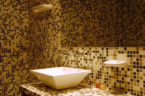 a bathroom with a sink on a tiled wall at Bohemia Hotel Boutique in Mendoza