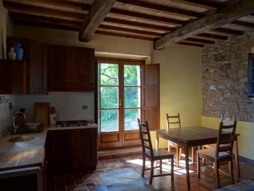 eine Küche mit einem Tisch und Stühlen sowie einem Fenster in der Unterkunft Agriturismo Palareta in Montecatini Val di Cecina