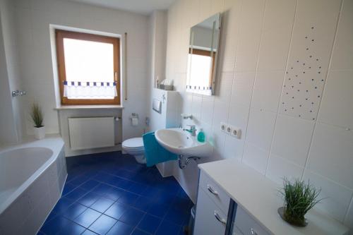 a white bathroom with a sink and a toilet at Ferienwohnung Weiher - Nähe Nürnberg / Messe in Schwanstetten