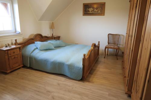 1 dormitorio con 1 cama y 1 silla en Lawendowa Galeria, en Krapkowice