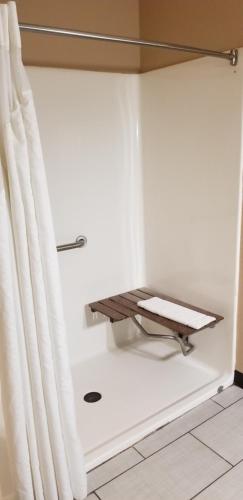 a shower with a curtain next to a bath tub at Super 8 by Wyndham Pontoon Beach IL/St. Louis MO Area in Pontoon Beach
