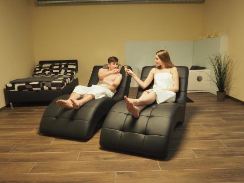 a man and a woman sitting on a couch at Pension Inspirace a Wellness self check-in in Kolín