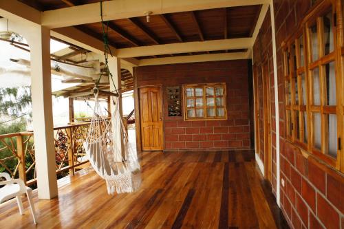 a porch with a hammock on a house at The Sea Garden House in Olón