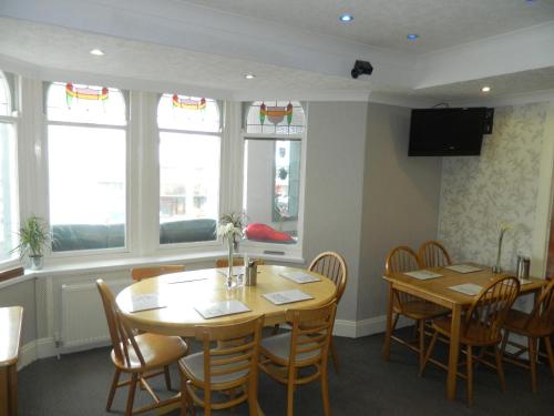 a dining room with a table and chairs and windows at Ocean Bay in Blackpool