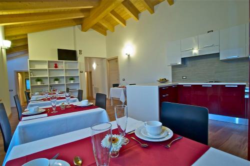 une grande salle à manger avec des tables blanches et des serviettes rouges dans l'établissement Terre Alte, à Buglio in Monte