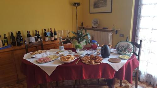 a table with food on it with bottles of wine at Allevamento B&B in Pozzolgroppo