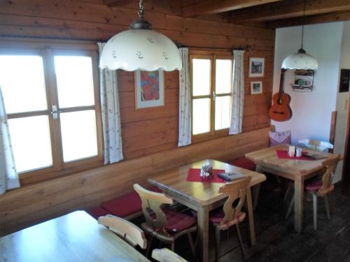 two tables and chairs in a room with windows at Weingut & Buschenschank Pölzl in Großklein