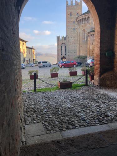an archway in a castle with cars parked in a parking lot at Dimora del Podestà in CastellʼArquato