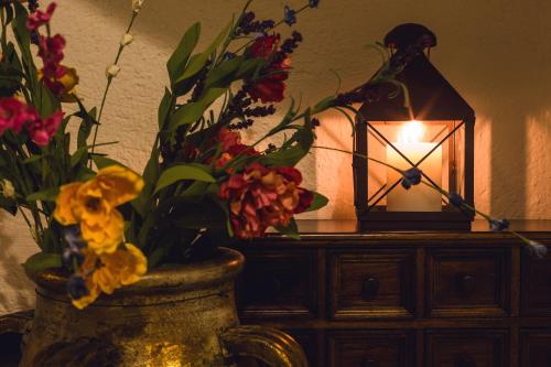 a vase filled with flowers next to a lantern at La Leyenda Boutique Hotel by Bunik in Playa del Carmen