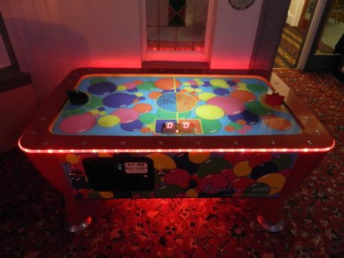 a game room with a pinball machine with lights at Ocean Bay in Blackpool