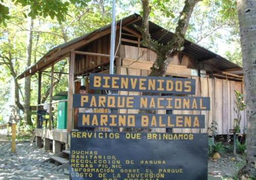 a large sign in front of a wooden building at Casa Morpho Uvita Guesthouse in Uvita