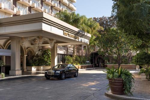 a black car parked in front of a building at Four Seasons Hotel Los Angeles at Beverly Hills in Los Angeles