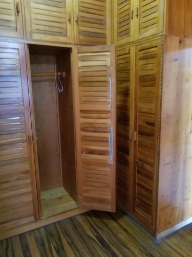 a walk in closet with wooden cabinets and a shower at Hotel Monte Campana Escazu in San José