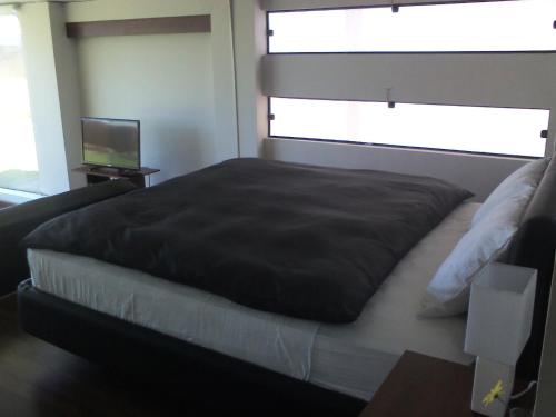 a bedroom with a large bed with a window at Hotel Onkel Inn Torres de Copacabana in Copacabana