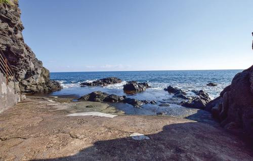 a group of rocks on a beach with the ocean at Villa Rama in Aci Castello