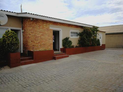 a brick house with a brick driveway in front of it at Villelodge Accommodation in Lüderitz
