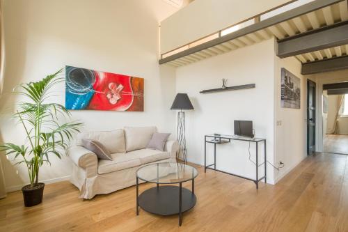 una sala de estar con un sofá y una mesa en Effetto Cittadella, en Lucca