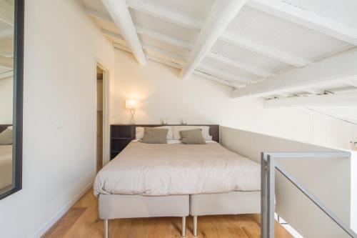 Un dormitorio con una cama en una habitación blanca. en Effetto Cittadella, en Lucca