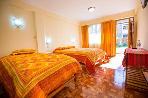 a bedroom with two beds and a window at Hotel Morales in Huaraz