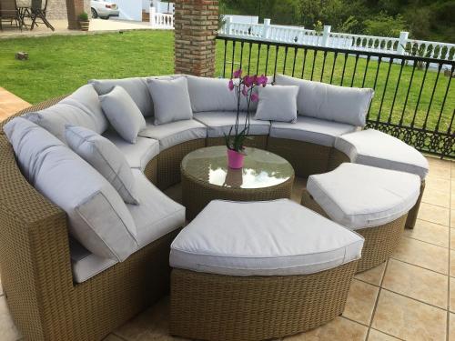 a wicker couch and two chairs and a table at Casa las Torres B&B in Iznate