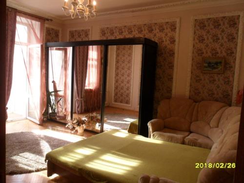 モスクワにあるMoscow Garden View Apartmentのリビングルーム(ソファ、鏡付)