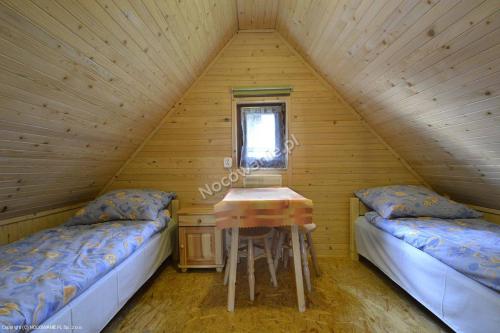 MizernaにあるPokoje gościnne u Danutyのベッド2台とテーブル付きの屋根裏部屋