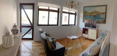 a living room with a table and chairs and a television at Family Espinho Porto Guesthouse in Espinho