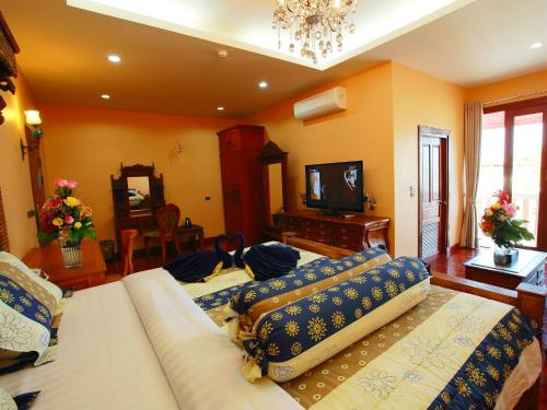 a living room with a couch and a television at At Chiang Mai Hotel in Chiang Mai