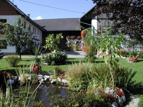 einen Garten mit einem Teich vor einem Gebäude in der Unterkunft Ferienhof Unterführholzergut in Klaus