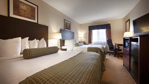 een hotelkamer met 2 bedden en een televisie bij Baymont by Wyndham Delaware in Delaware