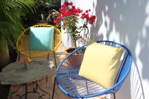 two chairs and a pillow on a patio at Hotel Villa Mozart y Macondo in Puerto Escondido