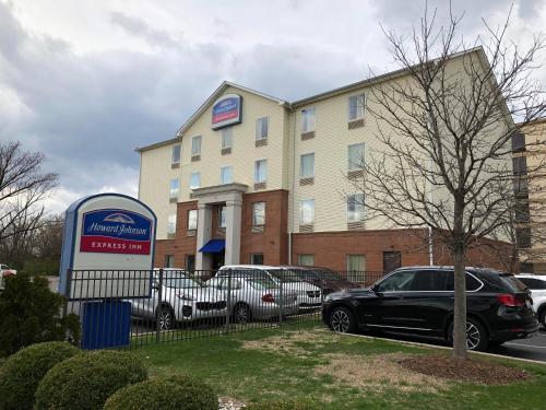 a building with cars parked in a parking lot at Howard Johnson by Wyndham Airport in Louisville