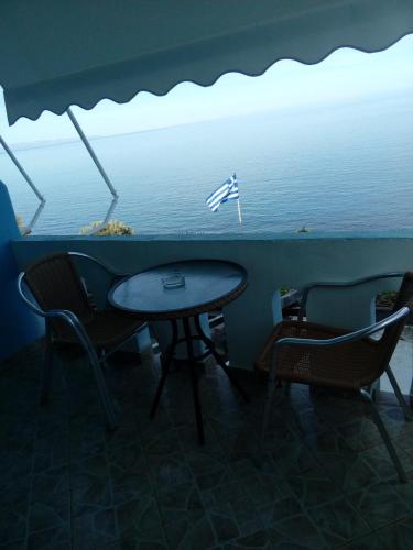 a table and chairs with a view of the water at Delfini in Akhladherí