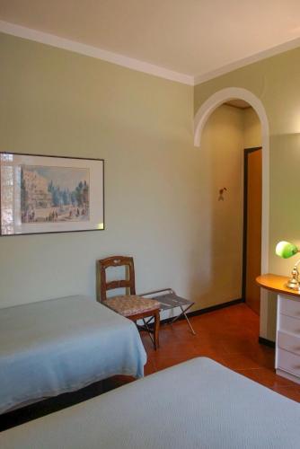 a room with two beds and a table and a chair at Hotel Locanda Mel in Calolziocorte